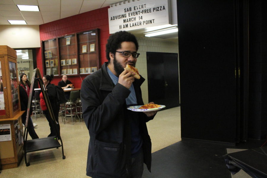 Cedric Peoples chomps into a delicious slice of steaming hot pizza. 