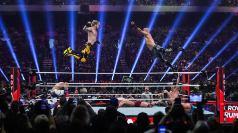 Logan Paul flies through the air to collide with wrestler Richochet during the 2023 Royal Rumble. Photo via Alex Bierens De Haan.