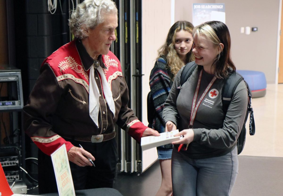 Temple+Grandin+signing+a+students+copy+of+Visual+Thinking%2C+Grandins+newest+book.+Photo+by+Aaron+Wendt.