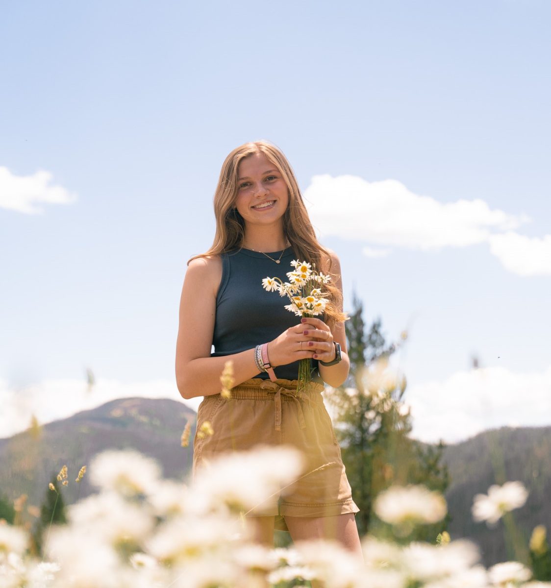 Photo of Mabry Mitchell in a Rocky Mountain daisy field. Photo by Emily Carr.