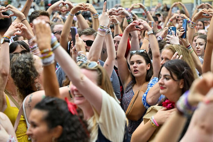 Fans of the singer Taylor Swift make a heart shape with their hands as they gather following the cancellation of three Taylor Swift concerts at Happel stadium after the government confirmed a planned attack at the venue, in Vienna, Austria August 8, 2024. REUTERS/Elisabeth Mandl/files