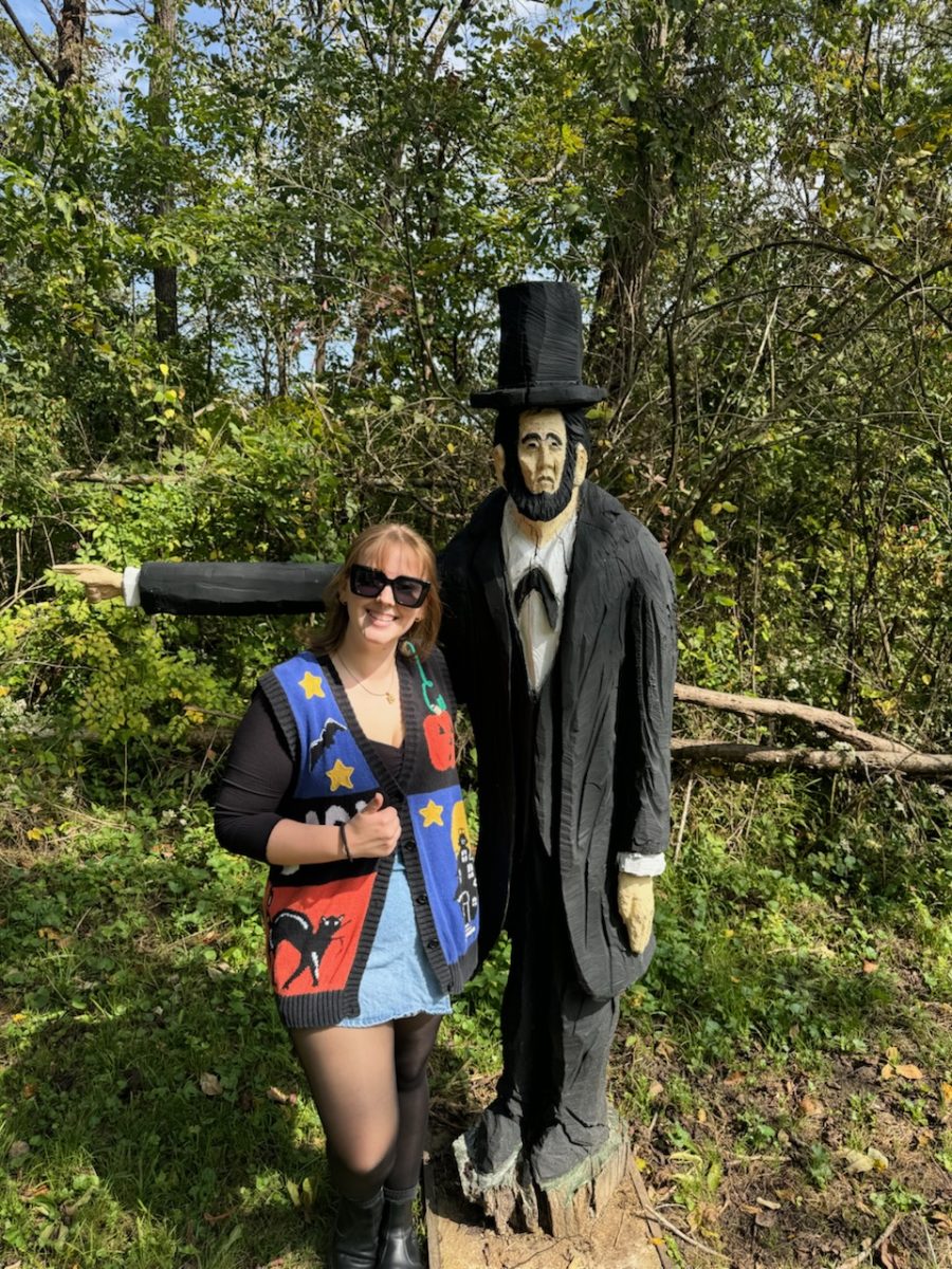 Payton with a carved wooded statue that could be Abraham Lincoln 