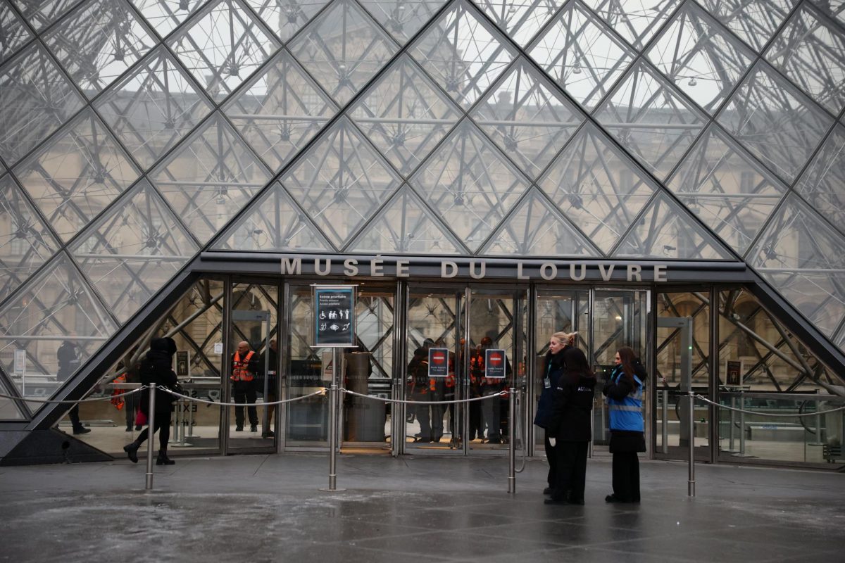 Employees stand in front of the glass Pyramid of the Louvre Museum whose opening has been postponed during a staff meeting about a strike over pay and working conditions at the museum, the state of the museum's buildings and staffing issues, after a spectacular heist which saw thieves make off with jewels in broad daylight, in Paris,  January 5, 2026. REUTERS/Sarah Meyssonnier